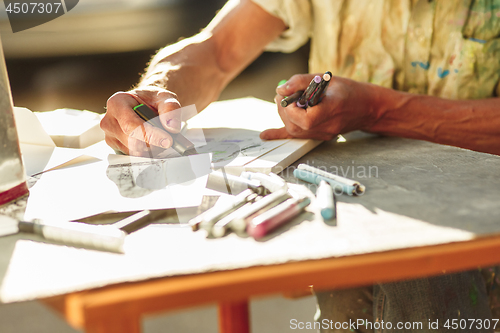 Image of Close up man working of Architect sketching a construction project on his plane project at site construction work