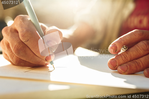 Image of Close up man working of Architect sketching a construction project on his plane project at site construction work
