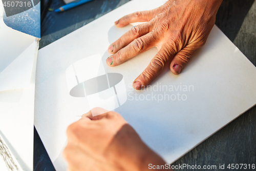 Image of Close up man working of Architect sketching a construction project on his plane project at site construction work