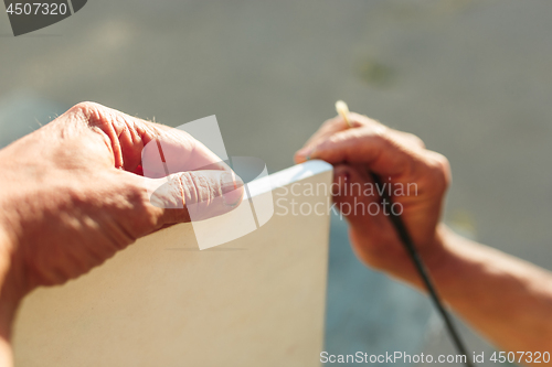 Image of Close up man working of Architect sketching a construction project on his plane project at site construction work