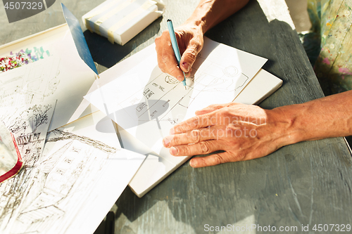 Image of Close up man working of Architect sketching a construction project on his plane project at site construction work