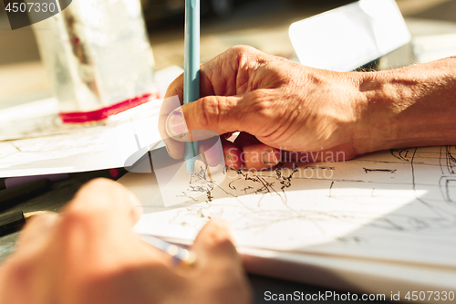 Image of Close up man working of Architect sketching a construction project on his plane project at site construction work