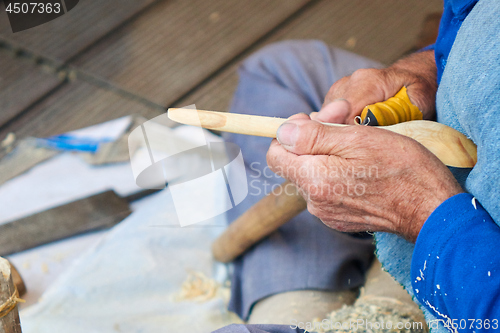 Image of the artisan makes a spoon of wood