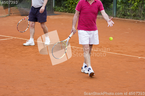 Image of Doubles tennis player with partner in the background