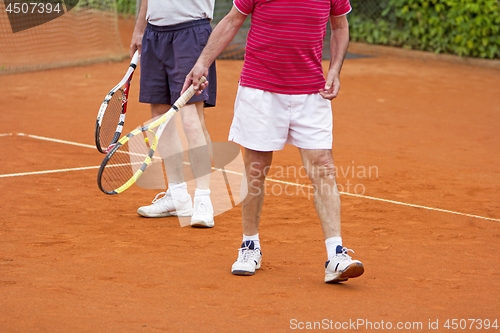 Image of Doubles tennis player with partner in the background