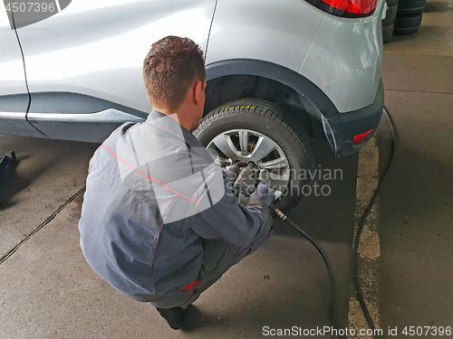 Image of Worker changes the car's tire