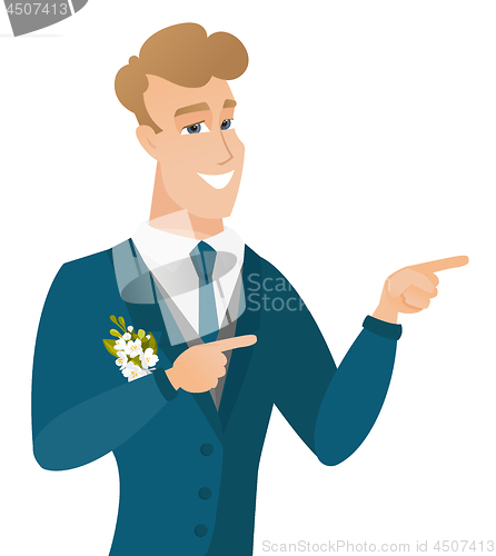 Image of Young caucasian groom pointing to the side.