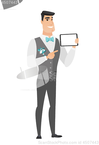 Image of Smiling groom holding tablet computer.