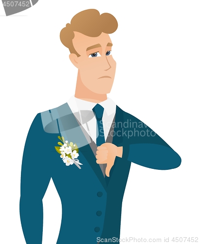Image of Disappointed caucasian groom with thumb down.