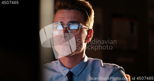 Image of man working on computer in dark office