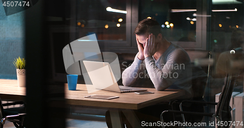 Image of man working on laptop in dark office