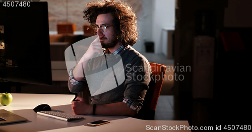 Image of man working on computer in dark office