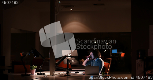 Image of man working on computer in dark office