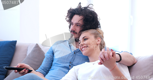 Image of Young couple on the sofa watching television