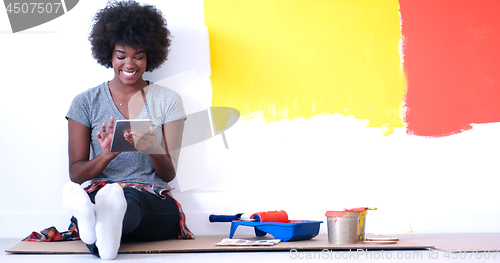 Image of black female painter sitting on floor