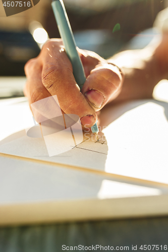 Image of Close up man working of Architect sketching a construction project on his plane project at site construction work