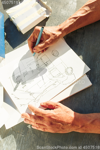 Image of Close up man working of Architect sketching a construction project on his plane project at site construction work