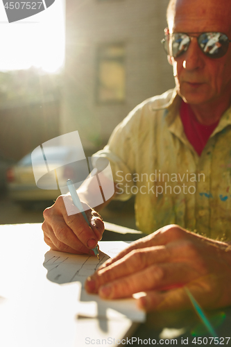 Image of Close up man working of Architect sketching a construction project on his plane project at site construction work