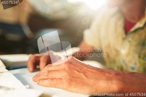 Image of Close up man working of Architect sketching a construction project on his plane project at site construction work