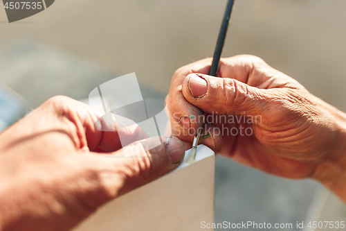 Image of Close up man working of Architect sketching a construction project on his plane project at site construction work
