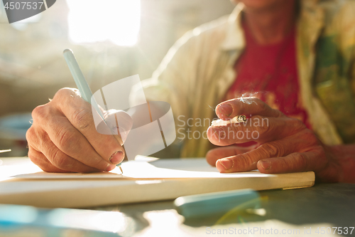 Image of Close up man working of Architect sketching a construction project on his plane project at site construction work