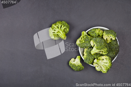 Image of Fresh green organic broccoli in white bowl on black board backgr