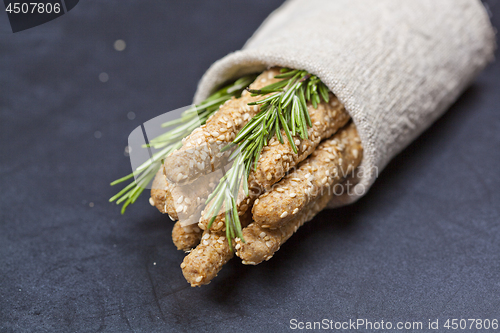 Image of Italian grissini bread sticks with rosemary herb on linen napkin