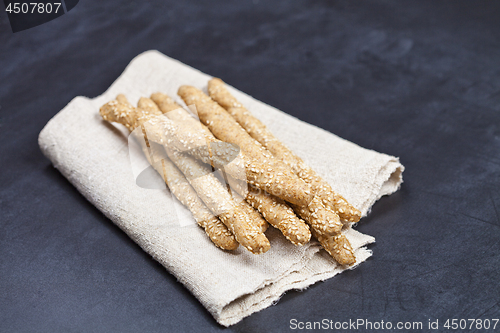 Image of Italian grissini bread sticks with sesame on linen napkin closeu
