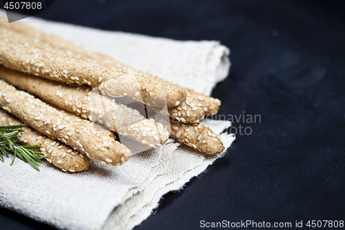 Image of Italian grissini bread sticks with rosemary herb on linen napkin