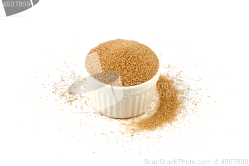 Image of Brown cane sugar in ceramic bowl isolated on white background. 