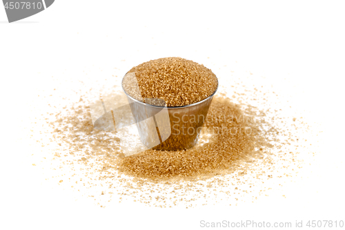 Image of Brown cane sugar in metal bowl isolated on white background.