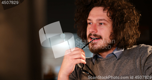 Image of man working on computer in dark office