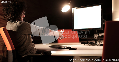 Image of man working on computer in dark office