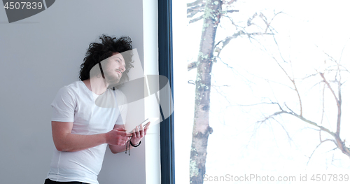 Image of young man using a tablet at home