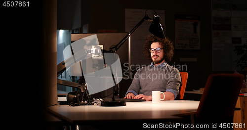 Image of man working on computer in dark office