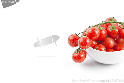 Image of Fresh organic wet cherry tomatoes bunch on ceramic bowl.