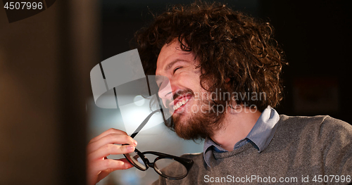 Image of man working on computer in dark office