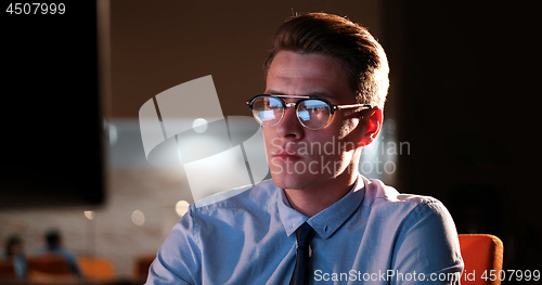 Image of man working on computer in dark office