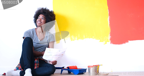 Image of black female painter sitting on floor