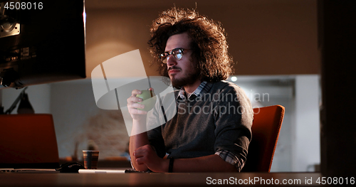 Image of man working on computer in dark office