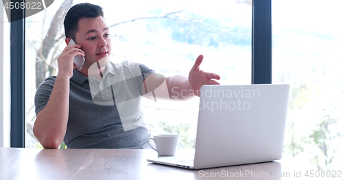 Image of businessman working using a laptop in startup office