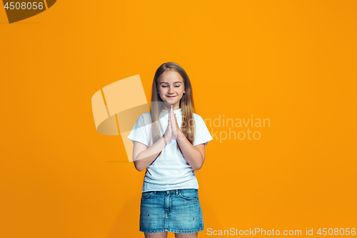 Image of Beautiful teen girl looking suprised isolated on orange