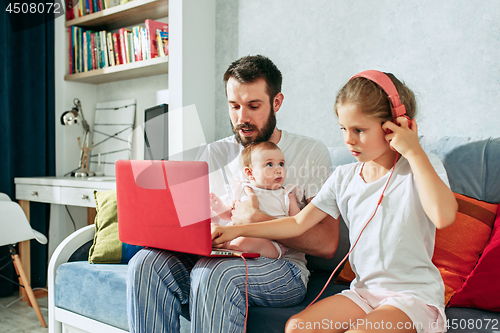 Image of father and his daughters at home