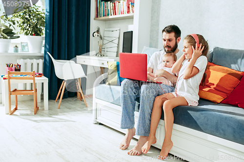 Image of father and his daughters at home