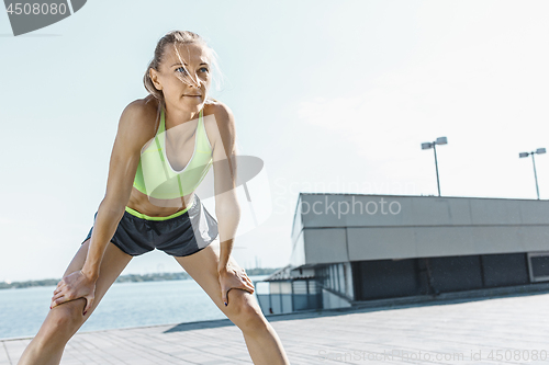 Image of Fit fitness woman doing stretching exercises outdoors at park