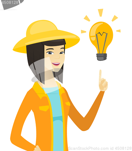 Image of Young asian farmer pointing at idea light bulb.