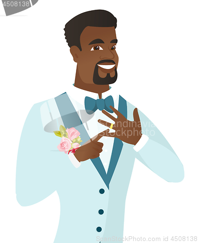 Image of Cheerful groom showing golden ring on his finger.