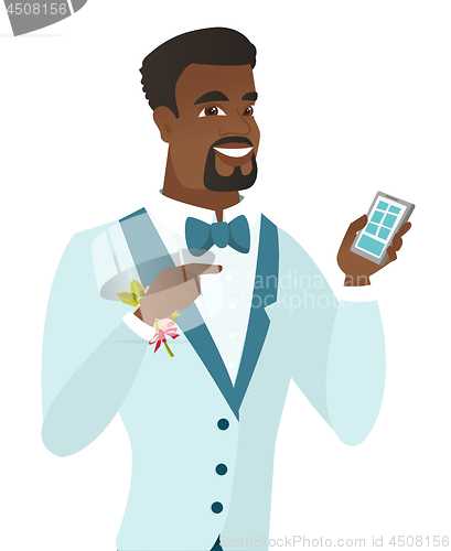 Image of African-american groom holding a mobile phone.