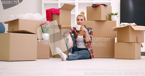 Image of woman with many cardboard boxes sitting on floor