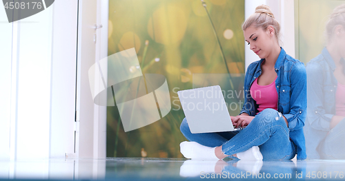 Image of young women using laptop computer on the floor